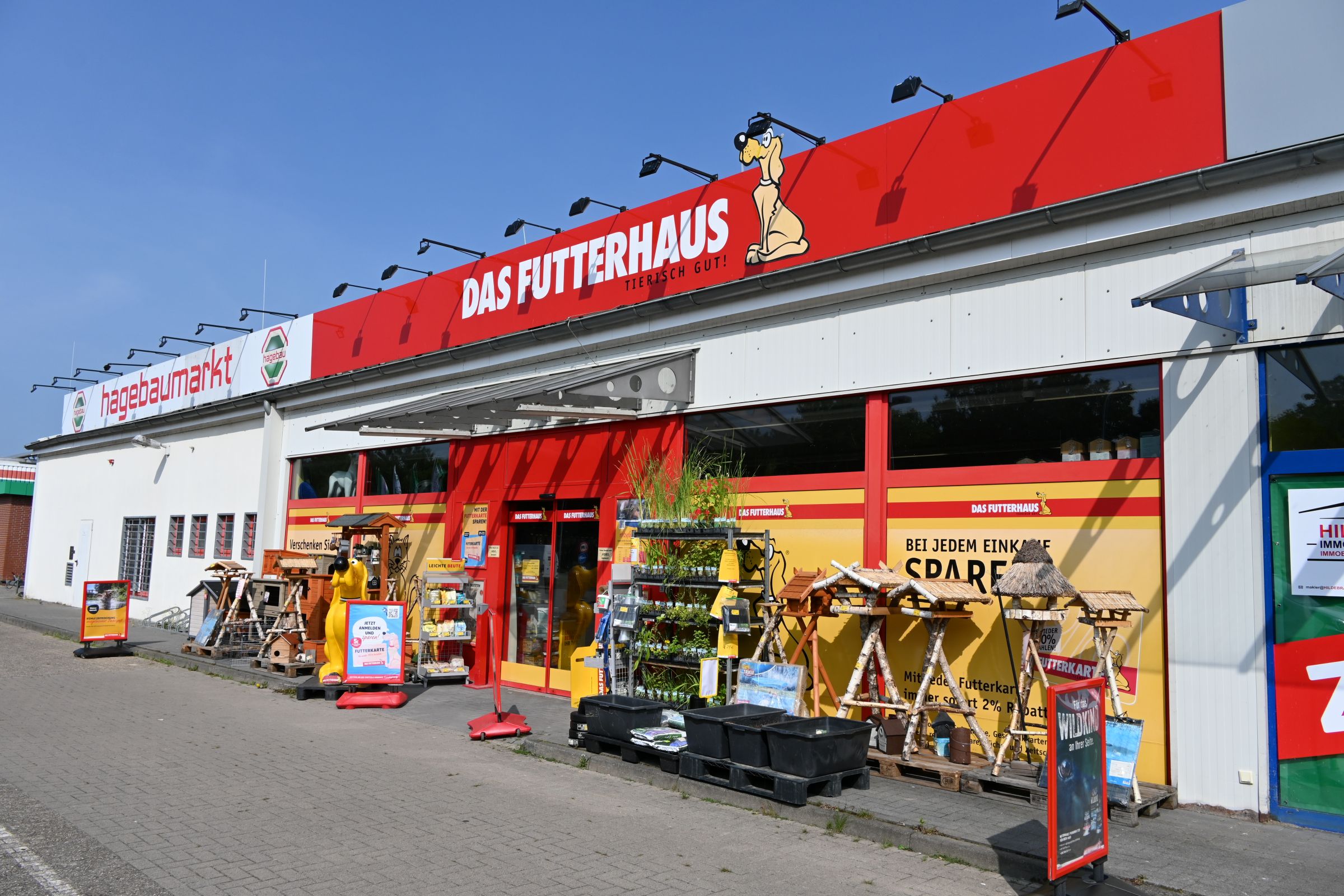 Eingang vom DAS FUTTERHAUS Brake mit großem roten Logo und verschiedenen Produkten im Außenbereich