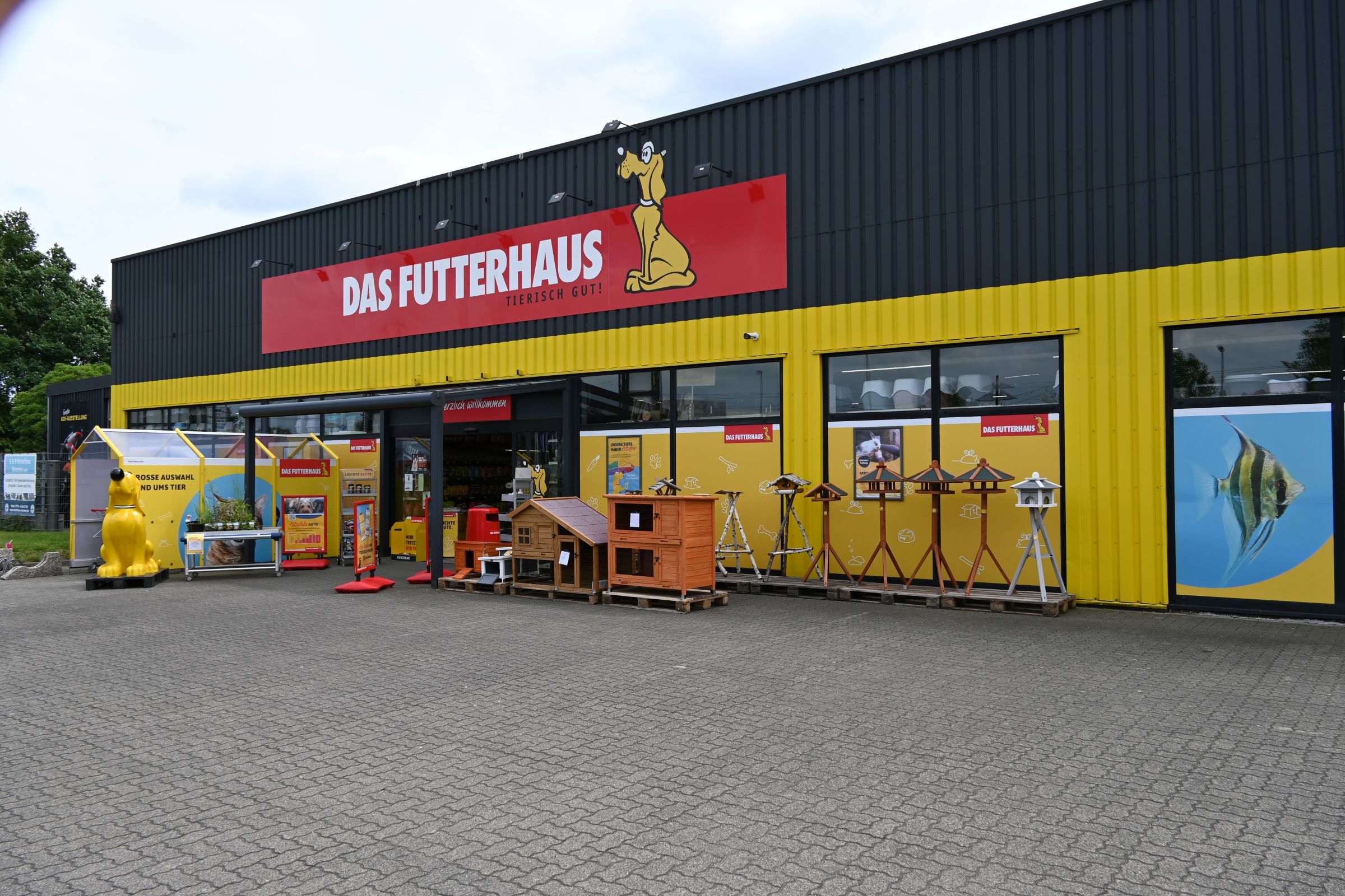 Der Eingang des DAS FUTTERHAUS Bremen-Weserpark mit großem roten Logo und gelber Fassade